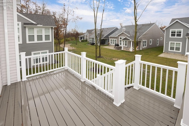 wooden deck featuring a residential view and a yard