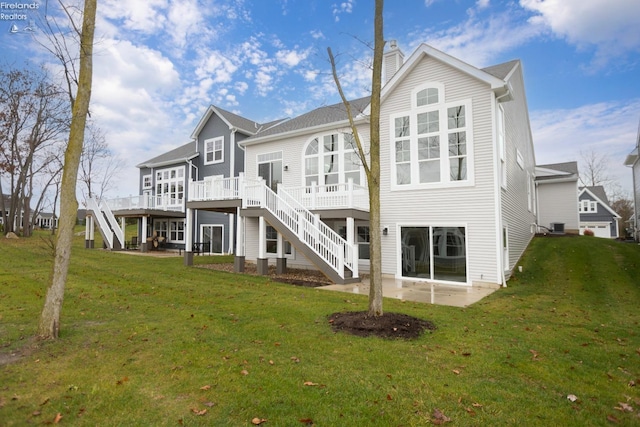 back of house featuring a deck, a patio, stairway, and a lawn