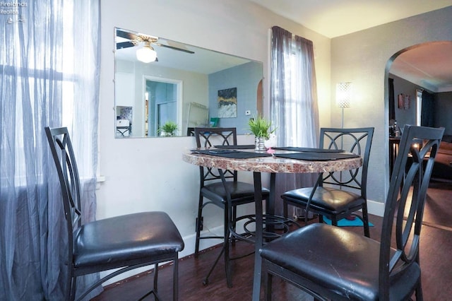 dining space featuring ceiling fan and dark wood-type flooring