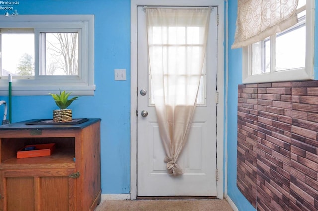 entryway featuring light colored carpet