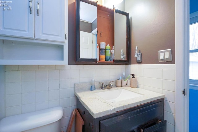 bathroom with tile walls, toilet, vanity, and tasteful backsplash