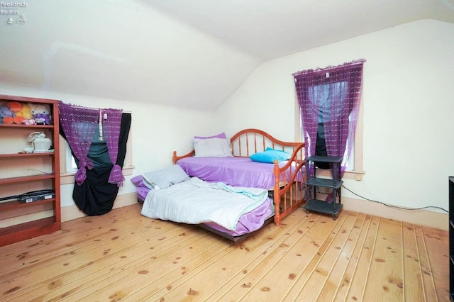 bedroom featuring light wood-type flooring and lofted ceiling