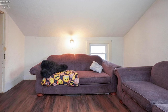 living room with dark hardwood / wood-style flooring and vaulted ceiling