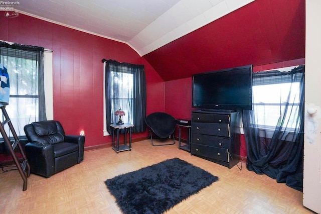 sitting room featuring lofted ceiling, light parquet floors, and a wealth of natural light