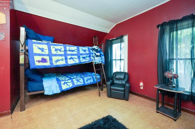 bedroom featuring lofted ceiling, light parquet floors, and crown molding