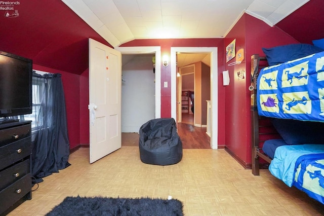 bedroom with lofted ceiling, light parquet floors, and crown molding