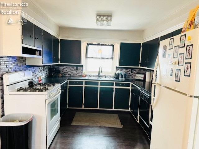 kitchen with white appliances, backsplash, dark hardwood / wood-style floors, and sink