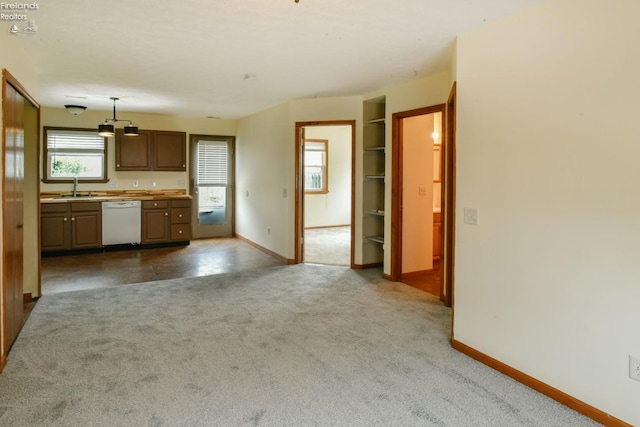 kitchen with white dishwasher, dark carpet, sink, and hanging light fixtures