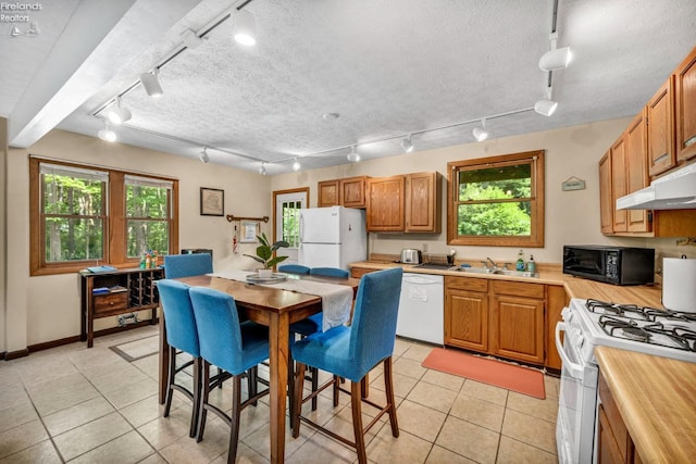 kitchen with light tile floors, white appliances, and rail lighting