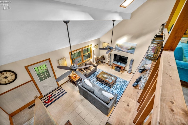 tiled living room with a textured ceiling, ceiling fan, and vaulted ceiling