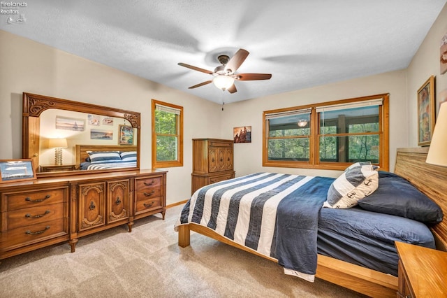 bedroom with light carpet, a textured ceiling, and ceiling fan