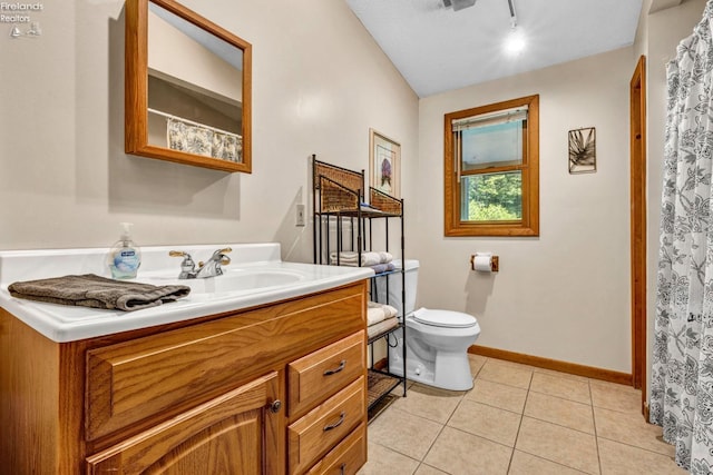 bathroom with tile flooring, toilet, track lighting, and oversized vanity