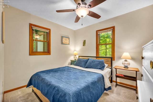 carpeted bedroom with ceiling fan and a textured ceiling