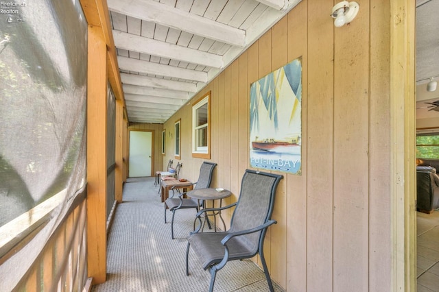 sunroom / solarium featuring beamed ceiling