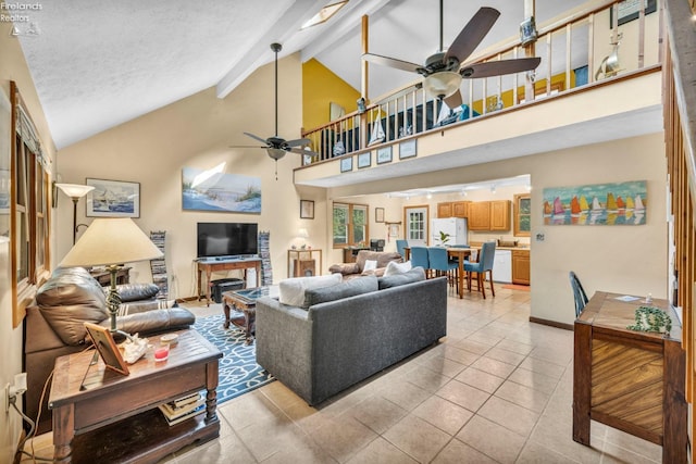 living room featuring ceiling fan, beamed ceiling, light tile flooring, a textured ceiling, and high vaulted ceiling