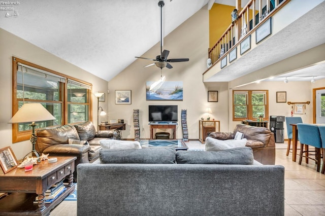 tiled living room featuring high vaulted ceiling, ceiling fan, and a textured ceiling