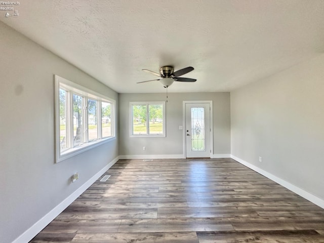 spare room featuring a textured ceiling, ceiling fan, and hardwood / wood-style floors