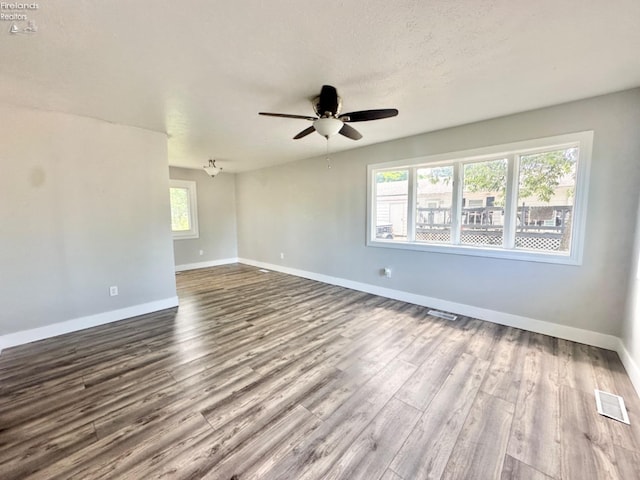 spare room with plenty of natural light, ceiling fan, and hardwood / wood-style floors