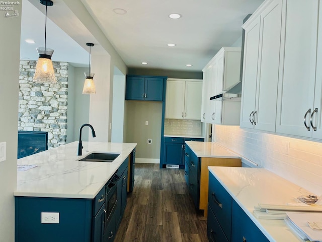 kitchen with blue cabinetry, white cabinets, a sink, and decorative light fixtures