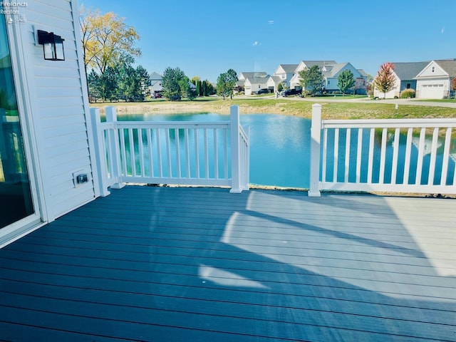 wooden deck with a yard, a water view, and a residential view