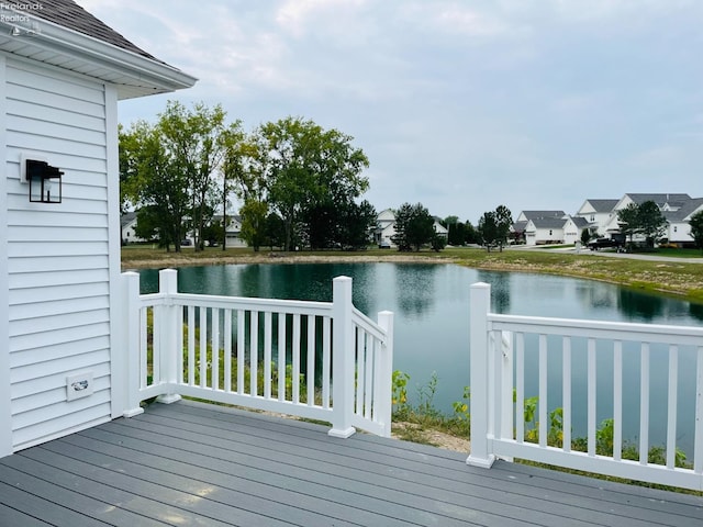 wooden terrace featuring a residential view and a water view