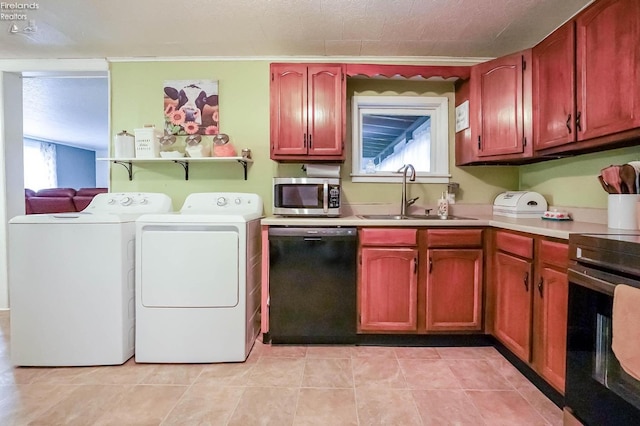 laundry room featuring light tile patterned floors, washer and dryer, sink, and plenty of natural light