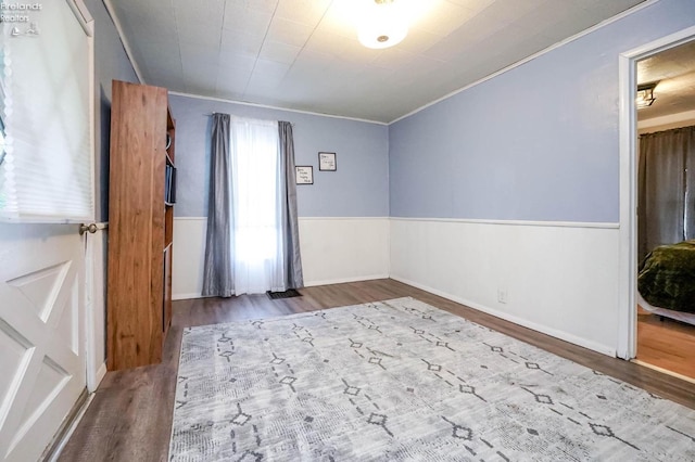 spare room featuring crown molding and dark wood-type flooring