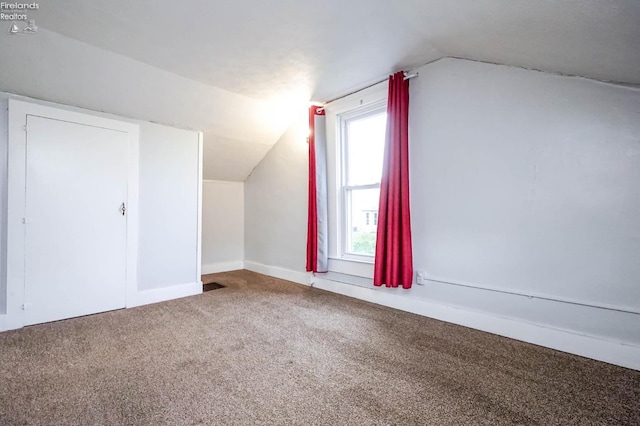 bonus room with carpet and vaulted ceiling