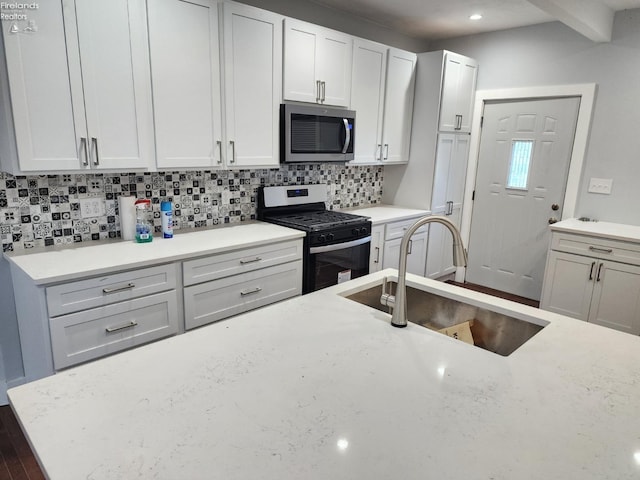 kitchen with sink, white cabinets, tasteful backsplash, and appliances with stainless steel finishes