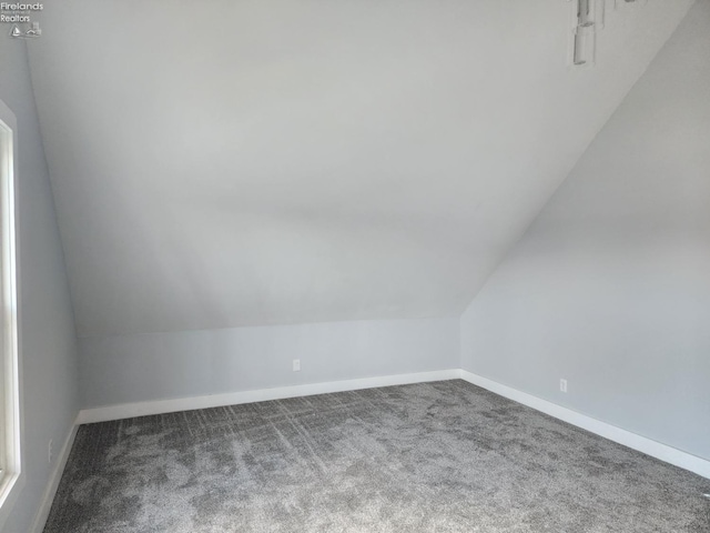 additional living space with vaulted ceiling and carpet