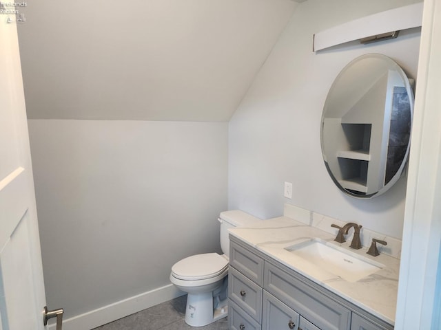 bathroom featuring tile patterned flooring, lofted ceiling, vanity, and toilet