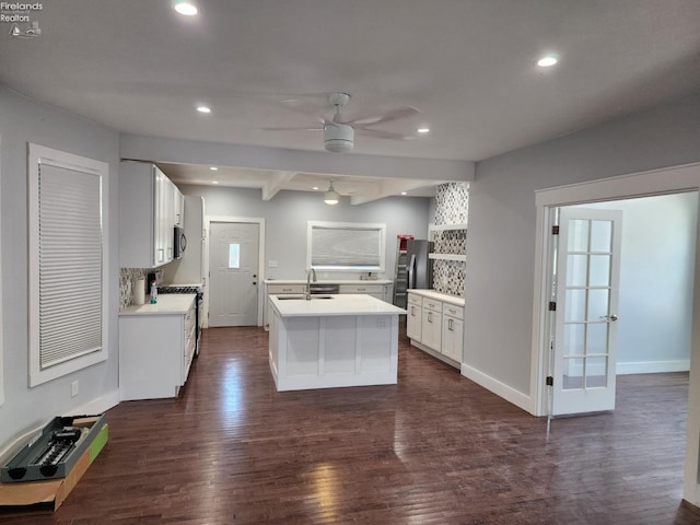 kitchen featuring a kitchen island with sink, stainless steel appliances, ceiling fan, dark hardwood / wood-style floors, and white cabinets