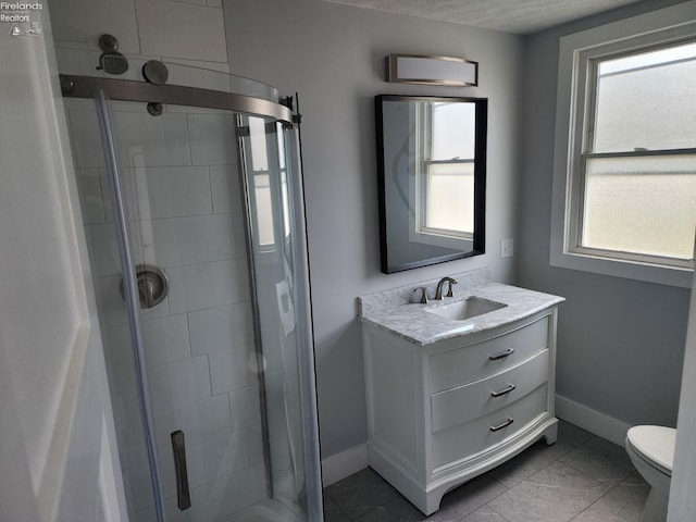 bathroom with toilet, an enclosed shower, tile patterned floors, and vanity