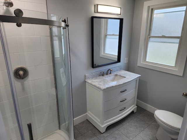 bathroom featuring toilet, a shower with door, vanity, and tile patterned flooring