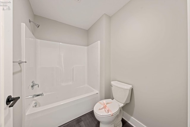 bathroom with tub / shower combination, hardwood / wood-style floors, and toilet