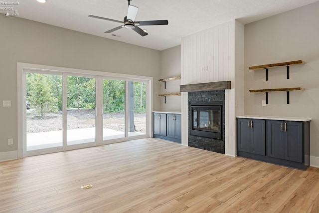 unfurnished living room with light hardwood / wood-style flooring, a fireplace, and ceiling fan