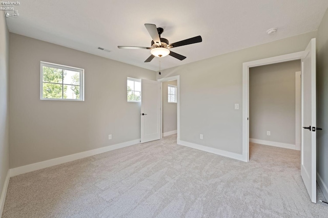 unfurnished bedroom with ceiling fan and light carpet