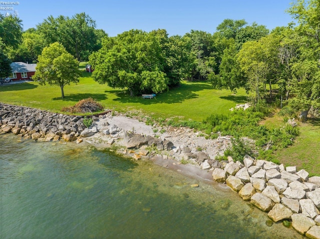 exterior space featuring a lawn and a water view