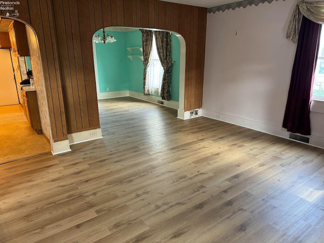 spare room with wood walls and hardwood / wood-style floors