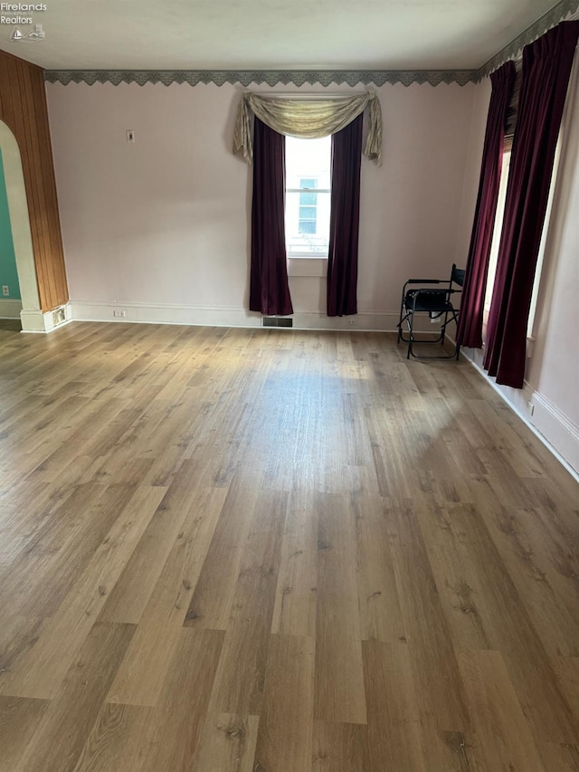1225 White Ave, Fremont, OH 43420 - empty room featuring arched walkways, visible vents, baseboards, and wood finished floors