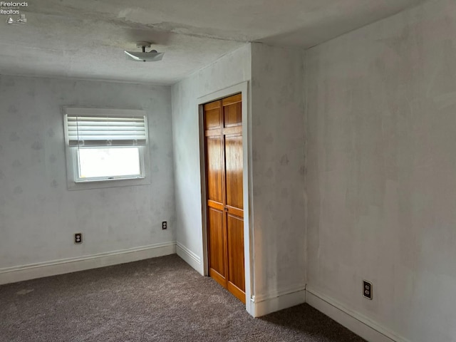 unfurnished bedroom featuring dark colored carpet