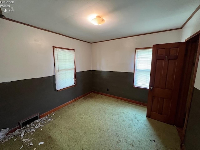 carpeted empty room featuring crown molding