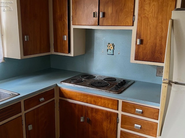 kitchen with cooktop and white fridge