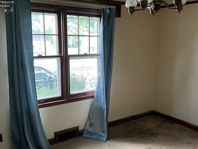 unfurnished room featuring an inviting chandelier