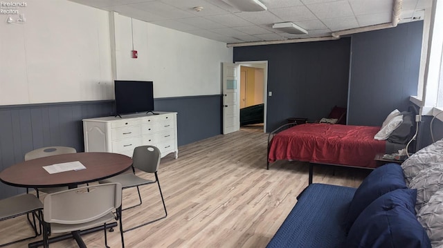 bedroom with a drop ceiling and light hardwood / wood-style flooring