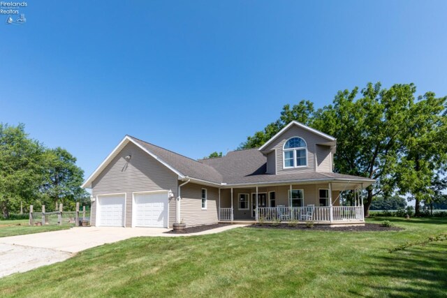 view of front facade with a garage, a porch, and a front yard