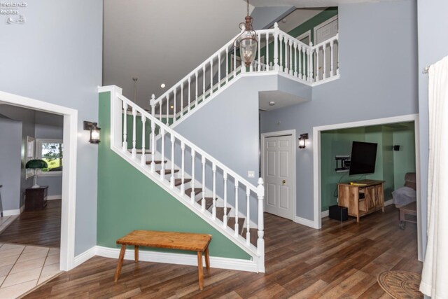 staircase featuring a high ceiling and dark hardwood / wood-style floors