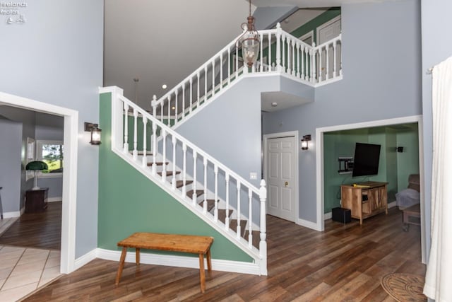 stairs with a high ceiling and hardwood / wood-style floors