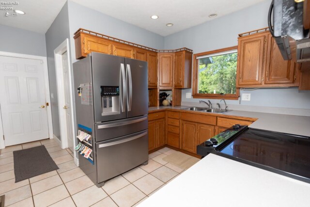 kitchen featuring light tile patterned flooring, sink, and stainless steel refrigerator with ice dispenser