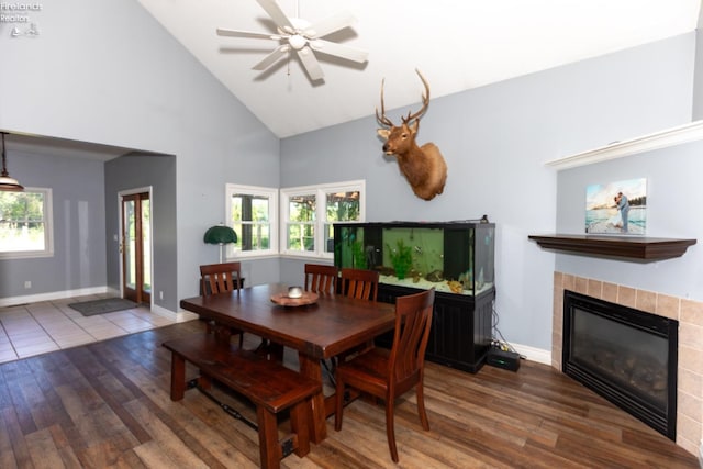 dining room with wood-type flooring, a tile fireplace, and a wealth of natural light